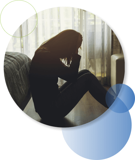 Woman Sitting By Bed With Head In Hands