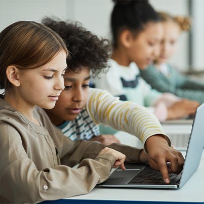Young Boy Helping Young Girl Using Computer