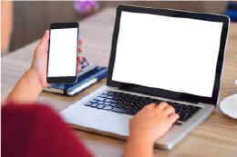 Person Checking Phone While Using Laptop