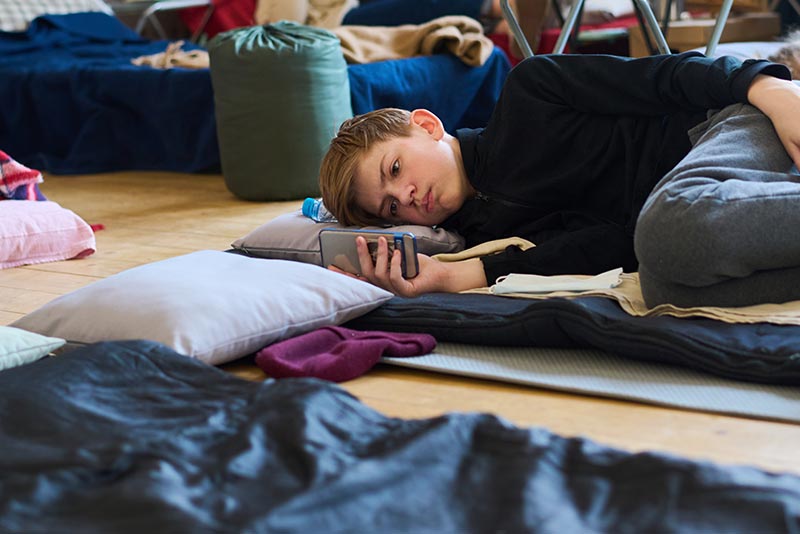 School Boy In Shelter On Phone